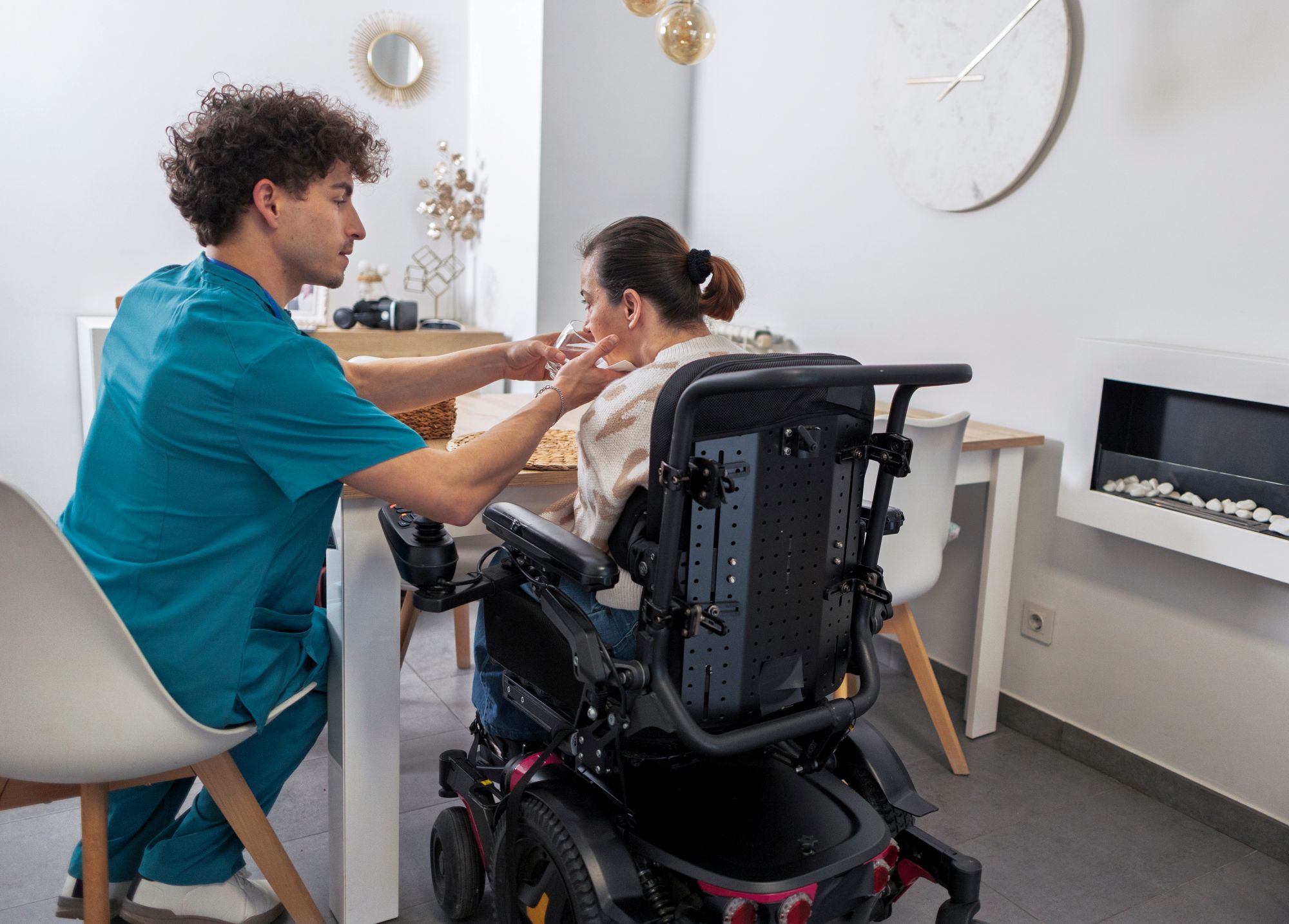 Caregiver assists a woman with disability at home